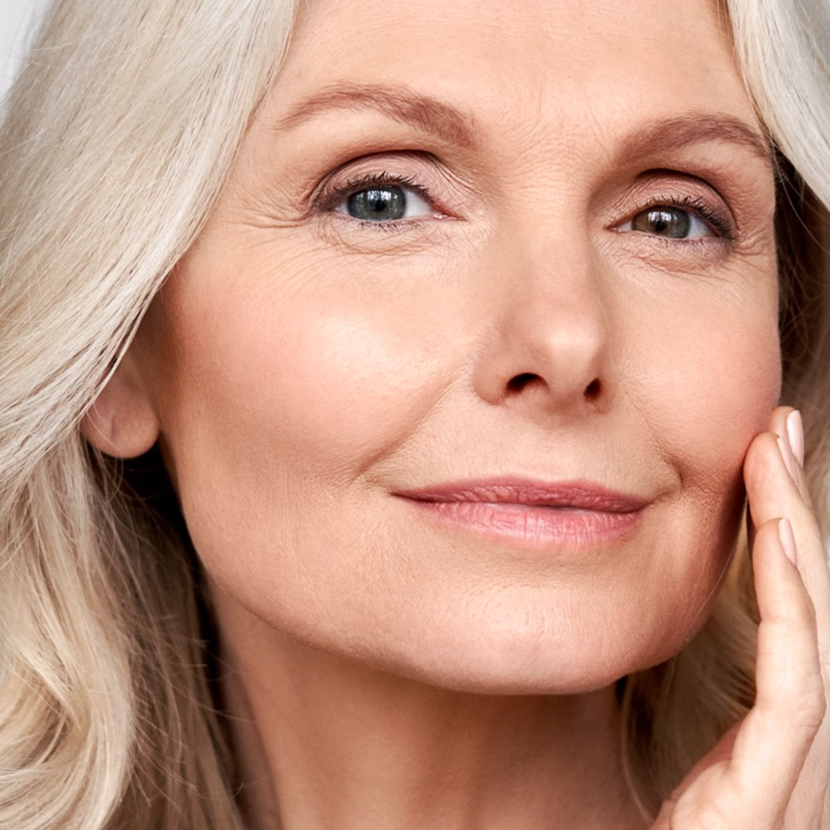 Woman touching skin to show tight skin.